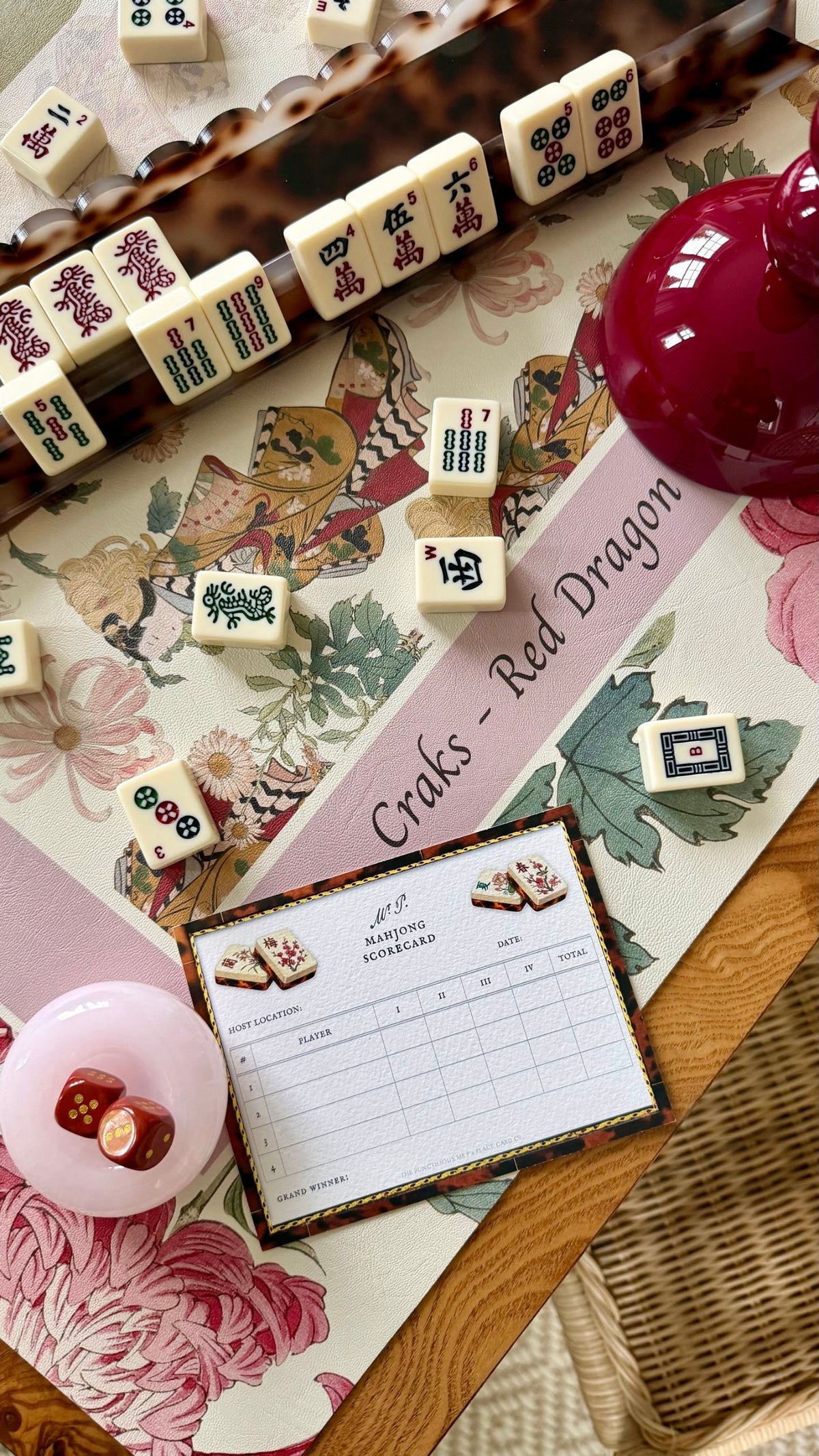 The Ivory Geisha mat with tiles in tortoise racks, the red vessel, a scorecard and the dice cup